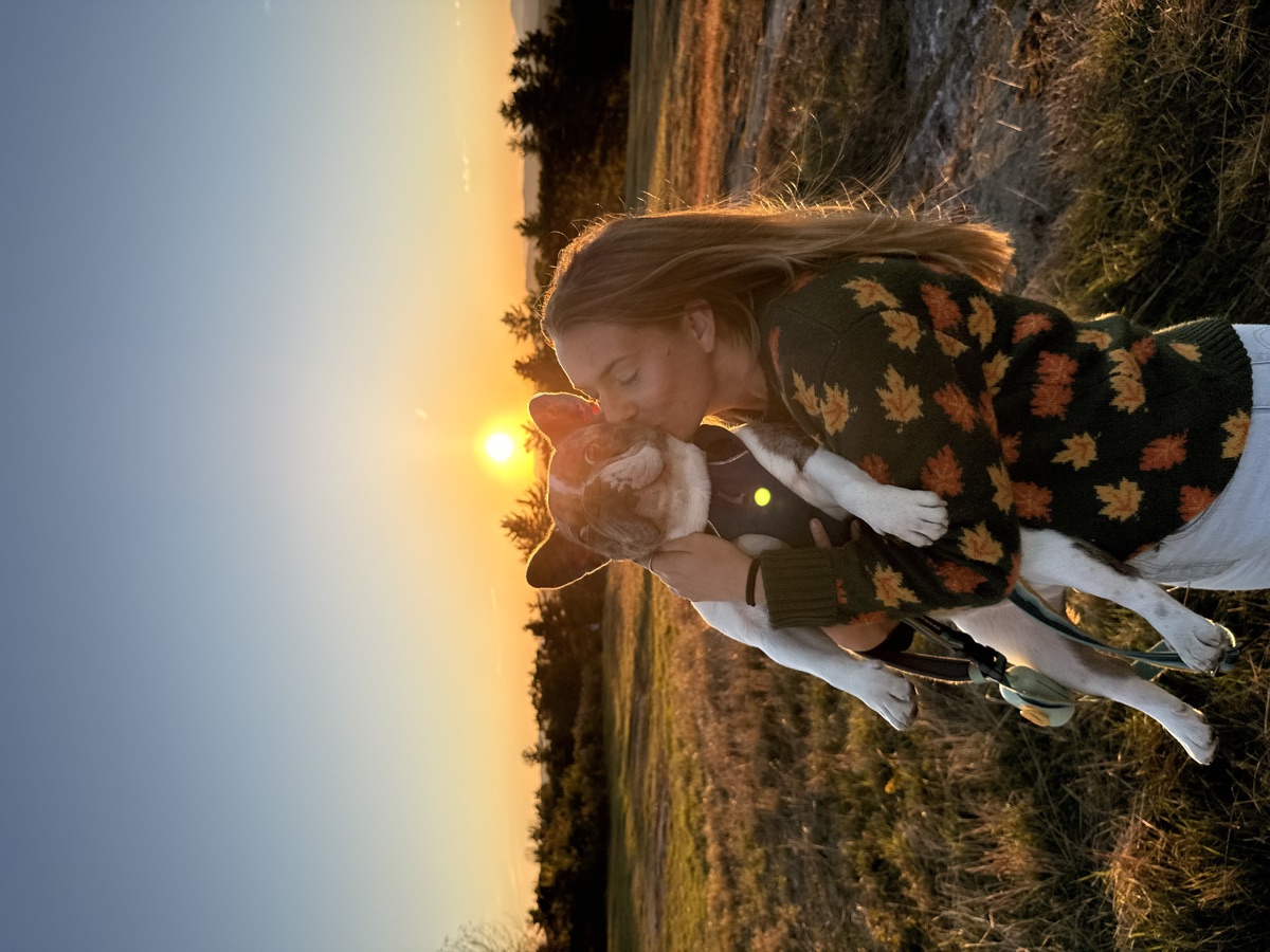 Sally kissing Louie in a field at golden hour